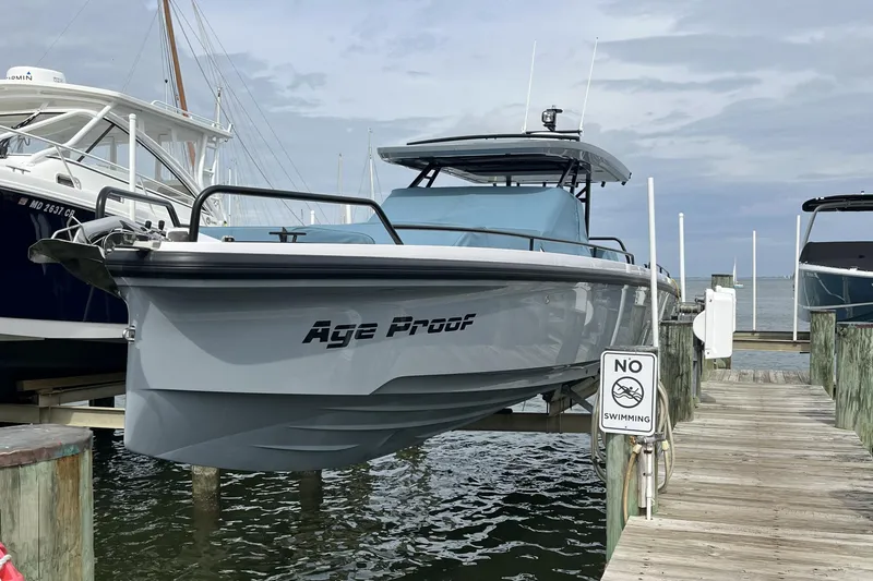 Slide: The Image of 2025 Axopar 37 Sun-Top boat docked, featuring sleek design and "Age Proof" branding. - 7