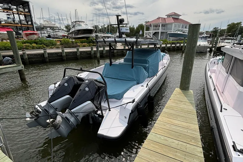 Slide: The Image of 2025 Axopar 37 Sun-Top boat docked with twin engines, covered seating area. - 8