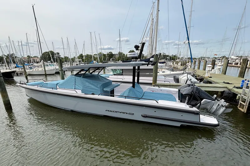 Slide: The Image of 2025 Axopar 37 Sun-Top boat docked at marina with protective covers. - 9
