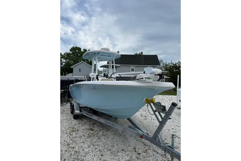 Slide: The Image of 2023 Tidewater 220 CC Adventure boat on trailer, parked outdoors. - 2