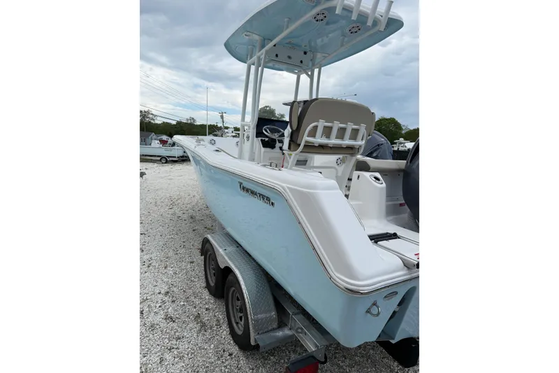 Slide: The Image of 2023 Tidewater 220 CC Adventure boat on trailer, side view, light blue hull. - 3