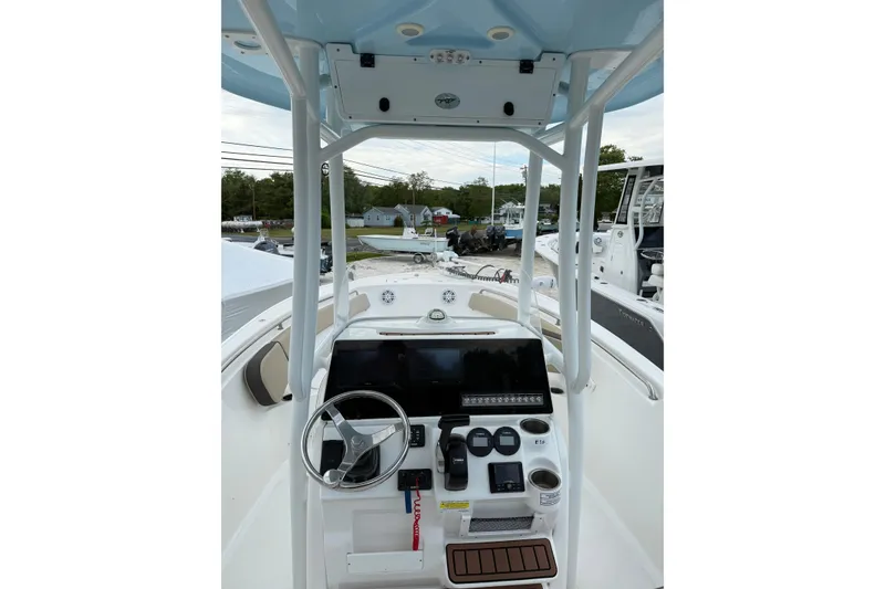 Slide: The Image of 2023 Tidewater 220 CC Adventure boat dashboard with steering wheel and controls. - 6
