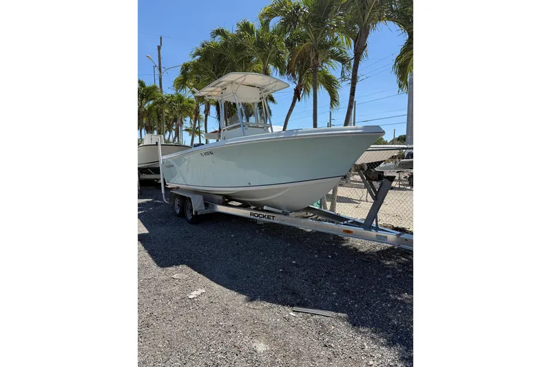 The Image of 2006 Sailfish 218 CC boat on trailer, parked under palm trees. - 0