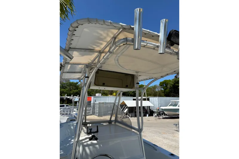 Slide: The Image of 2006 Sailfish 218 CC boat with T-top and rod holders in a sunny marina. - 5