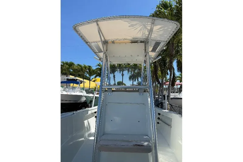 Slide: The Image of 2006 Sailfish 218 CC boat with T-top, docked near palm trees. - 6