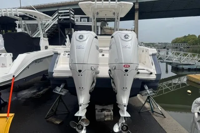 Slide: The Image of 2025 Robalo R250 Center Console boat with twin outboard engines docked at marina. - 2