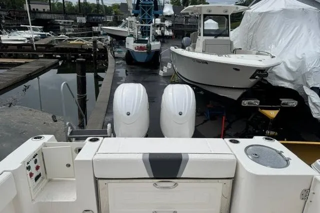 Slide: The Image of 2025 Robalo R250 Center Console boat docked with twin engines, marina background. - 4
