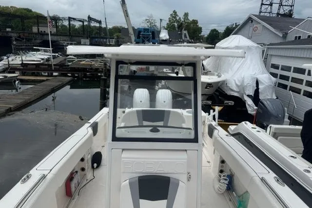 Slide: The Image of 2025 Robalo R250 Center Console boat docked at a marina, showcasing sleek design and spacious layout. - 8