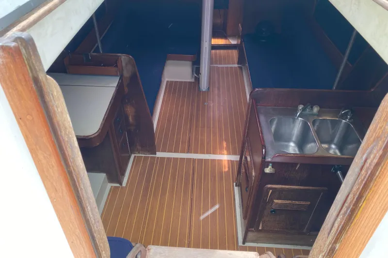 Slide: The Image of Interior of a 1981 C&C 40 sailboat with wood flooring and compact kitchen area. - 18