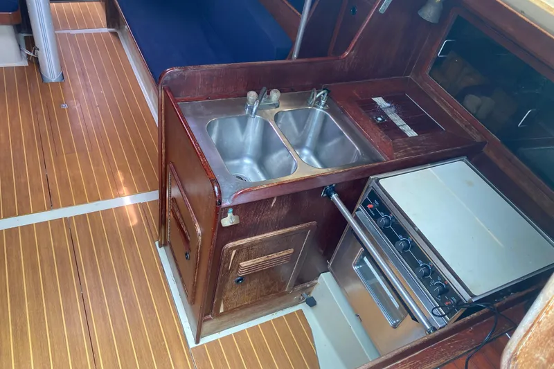 Slide: The Image of Interior of 1981 C&C 40 sailboat featuring a compact kitchen with stove and sink. - 19