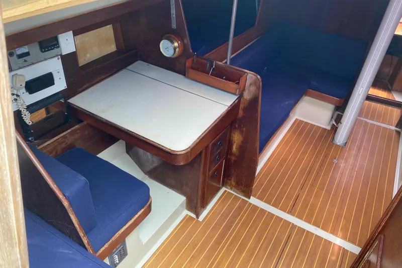 Slide: The Image of Interior of 1981 C&C 40 sailboat with wooden flooring and blue cushioned seating. - 20
