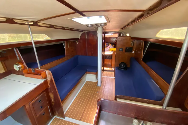 Slide: The Image of Interior of a 1981 C&C 40 sailboat with blue seating and wooden finishes. - 22