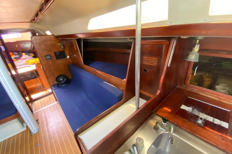 Slide: The Image of Interior of a 1981 C&C 40 sailboat with wooden finishes and blue seating. - 23