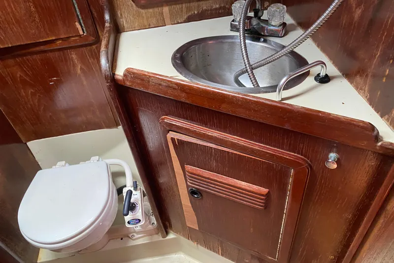 Slide: The Image of 1981 C&C 40 yacht bathroom with wooden cabinetry, sink, and marine toilet. - 27
