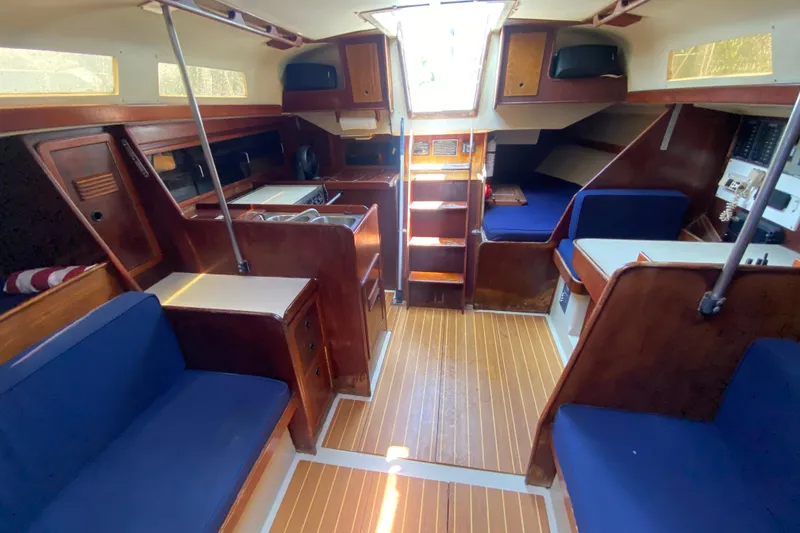 Slide: The Image of Interior of 1981 C&C 40 sailboat with wooden finishes and blue seating. - 28