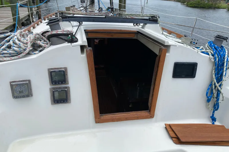 Slide: The Image of Cockpit of a 1981 C&C 40 sailboat with navigation instruments and coiled ropes. - 37