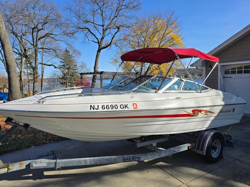 The Image of 2000 Mariah 20 Shabah boat with red canopy on trailer, parked in driveway. - 0