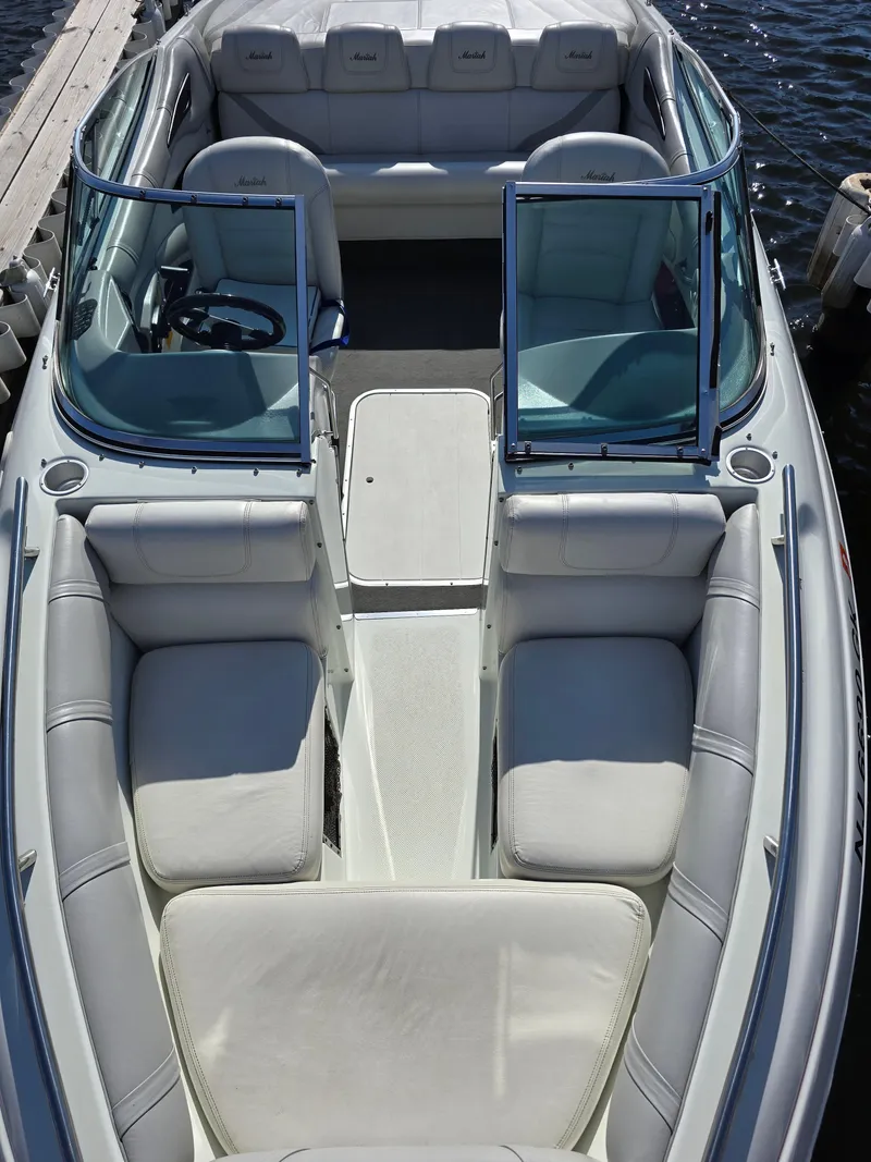 Slide: The Image of 2000 Mariah 20 Shabah boat with white seating and open deck on water. - 13