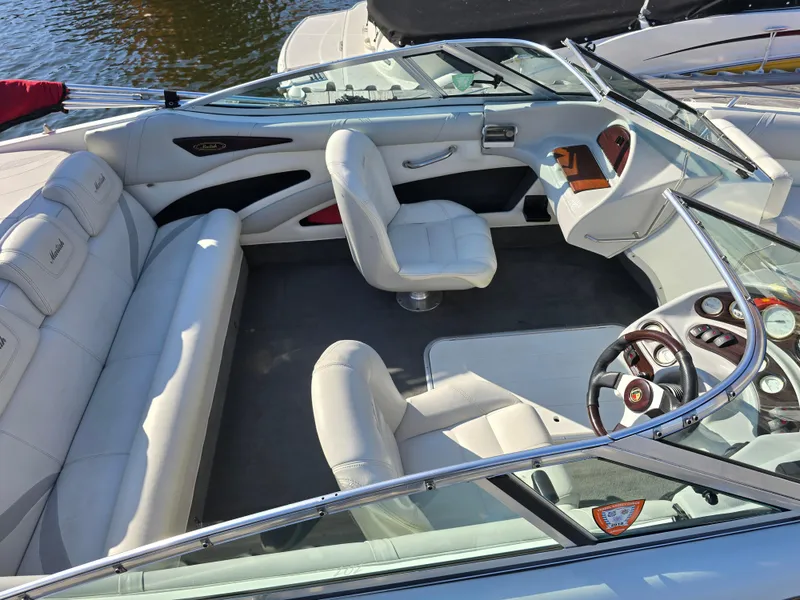 Slide: The Image of Interior of a 2000 Mariah 20 Shabah boat with white seating and steering wheel. - 5