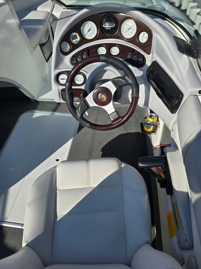 Slide: The Image of Steering wheel and dashboard of a 2000 Mariah 20 Shabah boat, featuring gauges and controls. - 8