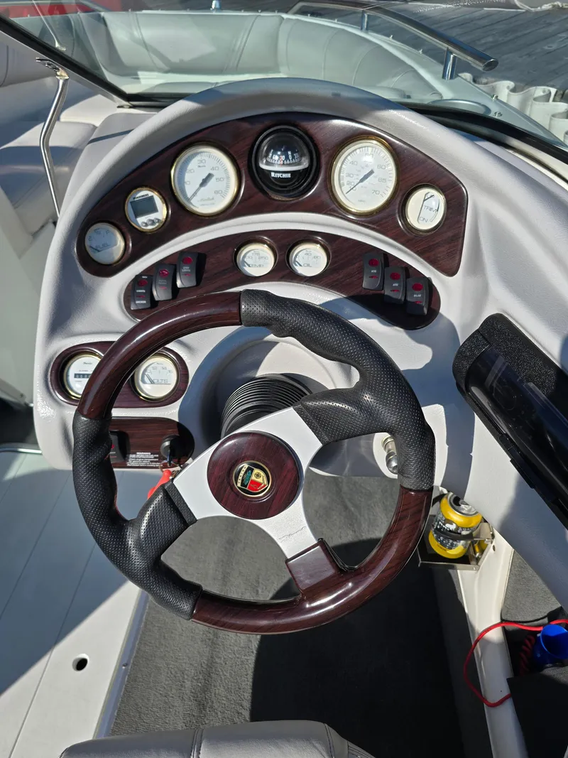 Slide: The Image of Steering wheel and dashboard of a 2000 Mariah 20 Shabah boat, featuring multiple gauges. - 9