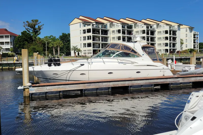 Slide: The Image of 2004 Cruisers Yachts 400 Express docked near waterfront apartments. - 1