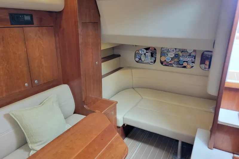 Slide: The Image of Interior of 2004 Cruisers Yachts 400 Express with cozy seating and wooden cabinetry. - 11