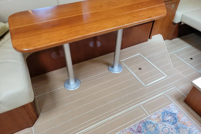 Slide: The Image of Interior of 2004 Cruisers Yachts 400 Express with wooden table and beige flooring. - 13