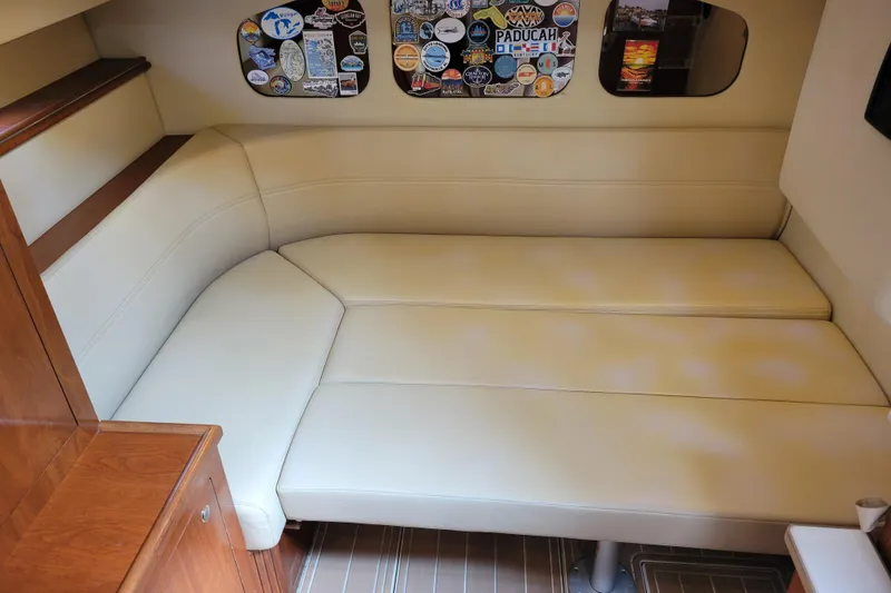 Slide: The Image of 2004 Cruisers Yachts 400 Express interior with beige seating and decorative wall stickers. - 14
