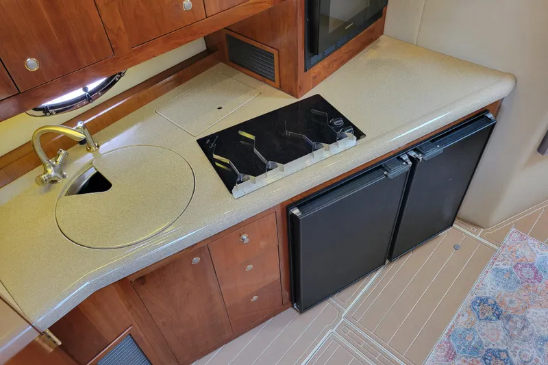 Slide: The Image of 2004 Cruisers Yachts 400 Express kitchen with sink, stove, and dual refrigerators. - 16