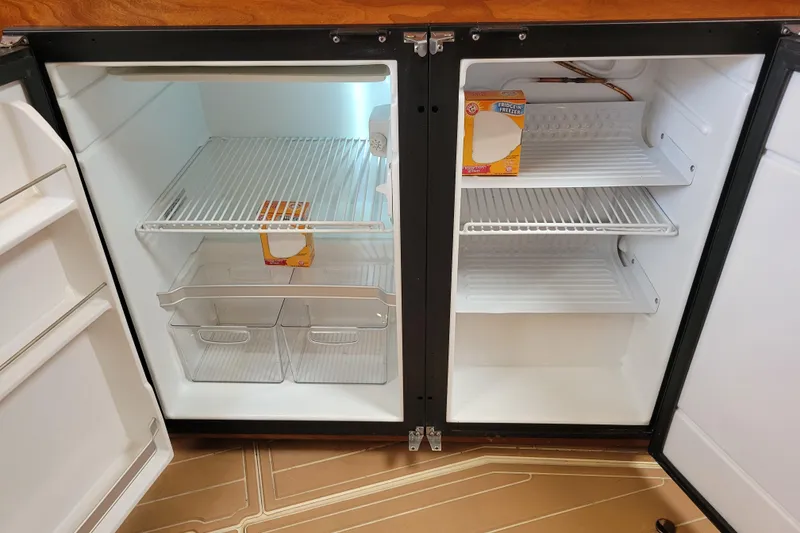 Slide: The Image of Open refrigerator in 2004 Cruisers Yachts 400 Express, containing baking soda boxes. - 18