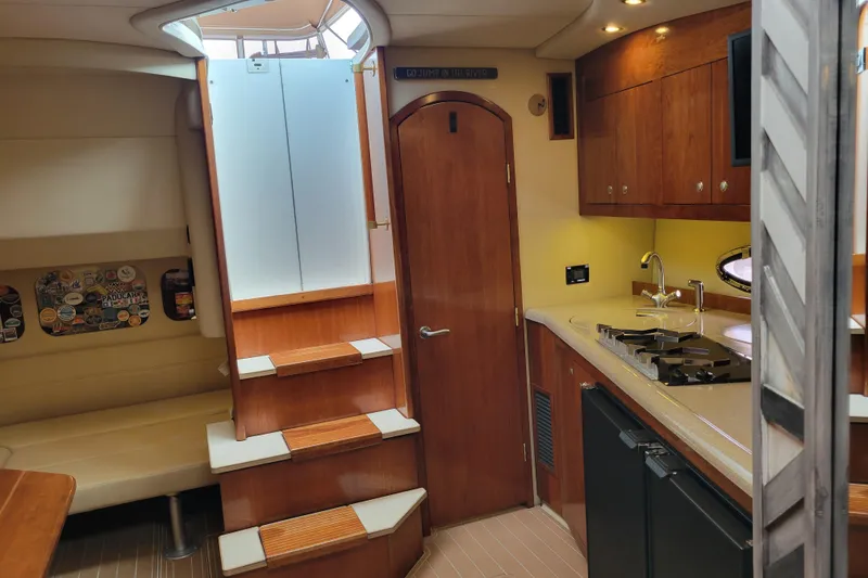 Slide: The Image of Interior of 2004 Cruisers Yachts 400 Express, featuring kitchen and seating area. - 21