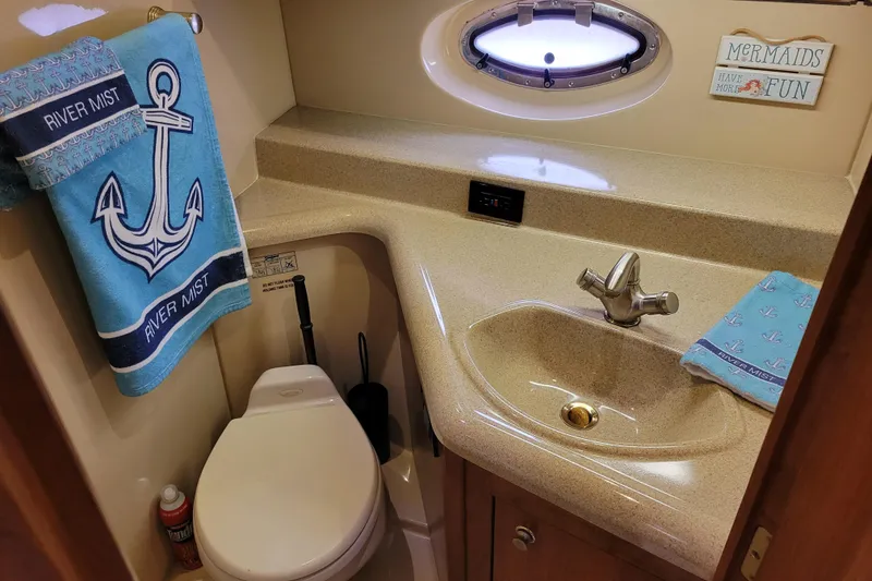 Slide: The Image of Bathroom of 2004 Cruisers Yachts 400 Express with nautical decor and porthole window. - 24
