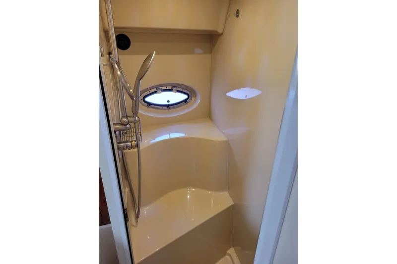 Slide: The Image of Shower area in 2004 Cruisers Yachts 400 Express with porthole and handheld showerhead. - 25
