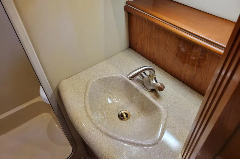 Slide: The Image of 2004 Cruisers Yachts 400 Express bathroom sink with wooden cabinetry and modern faucet. - 28