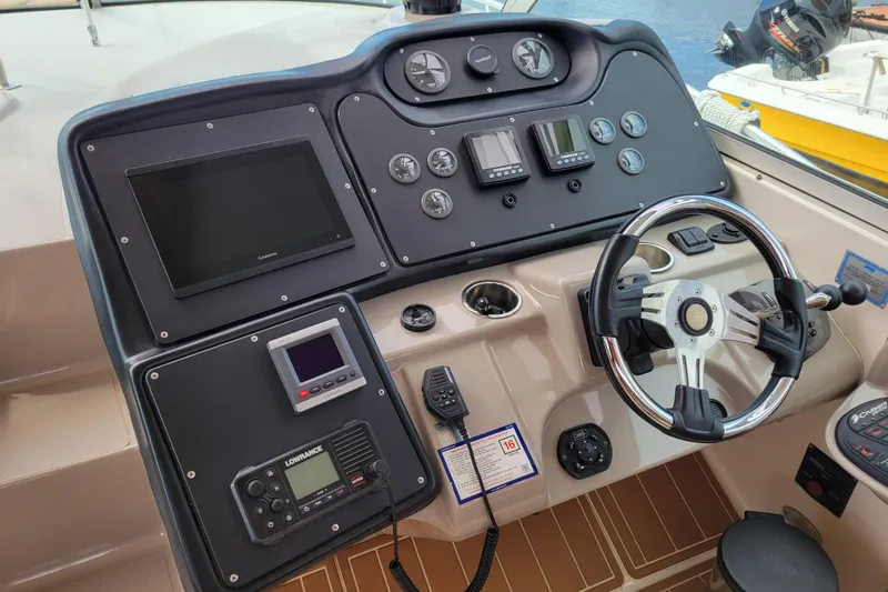 Slide: The Image of Control panel of a 2004 Cruisers Yachts 400 Express with steering wheel and navigation instruments. - 31