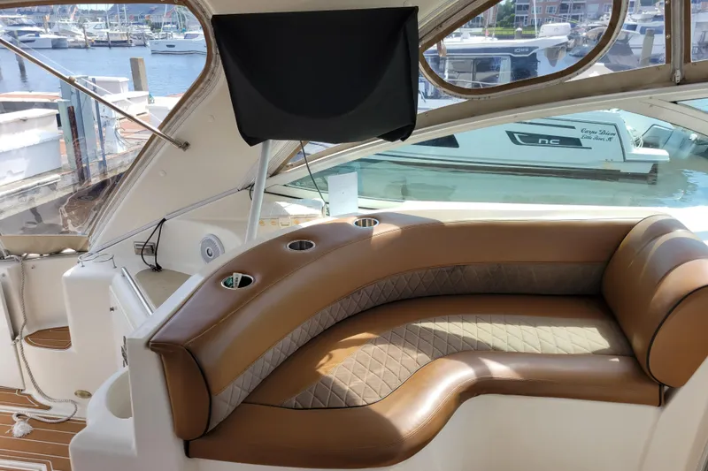 Slide: The Image of Luxurious seating area on a 2004 Cruisers Yachts 400 Express, docked at a marina. - 32