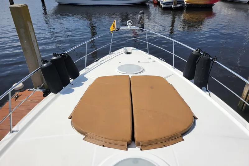 Slide: The Image of 2004 Cruisers Yachts 400 Express boat deck with tan cushions, docked at marina. - 39