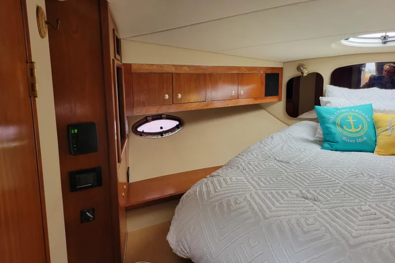 Slide: The Image of Interior cabin of 2004 Cruisers Yachts 400 Express with cozy bedding and wooden cabinetry. - 4