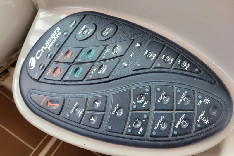 Slide: The Image of Control panel of a 2004 Cruisers Yachts 400 Express with various labeled buttons. - 43
