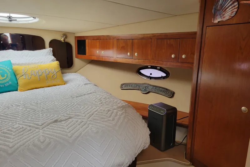 Slide: The Image of Cozy cabin interior of 2004 Cruisers Yachts 400 Express with bed and wooden cabinets. - 5
