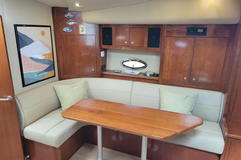 Slide: The Image of 2004 Cruisers Yachts 400 Express interior with wooden cabinetry and cozy seating area. - 9