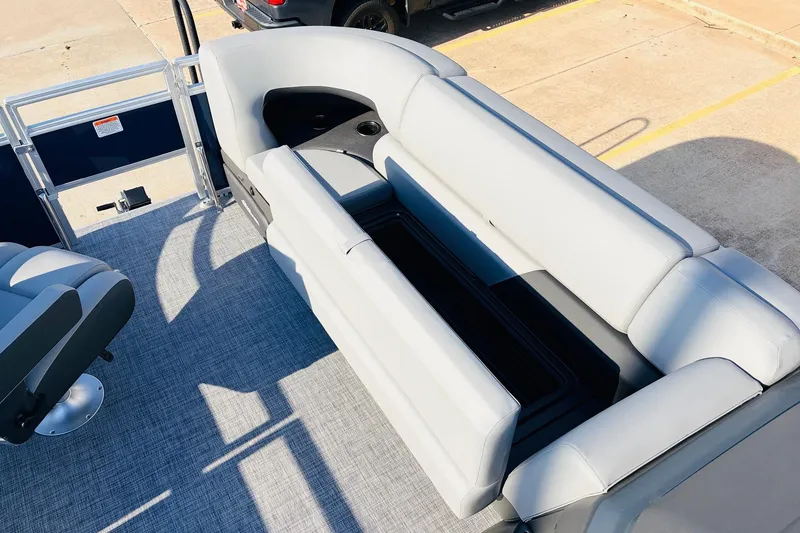 Slide: The Image of 2026 Sun Tracker SportFish 20 DLX pontoon boat interior with gray seating and storage. - 18