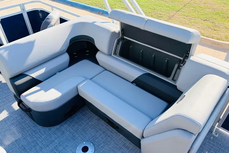 Slide: The Image of 2026 Sun Tracker SportFish 20 DLX boat interior with cushioned seating and storage compartment. - 25