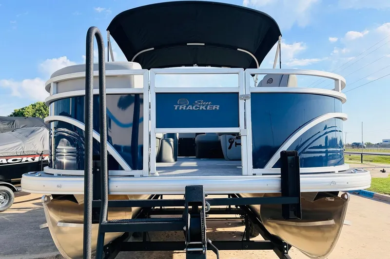 Slide: The Image of 2026 Sun Tracker SportFish 20 DLX pontoon boat on trailer, blue exterior, sunny day. - 3
