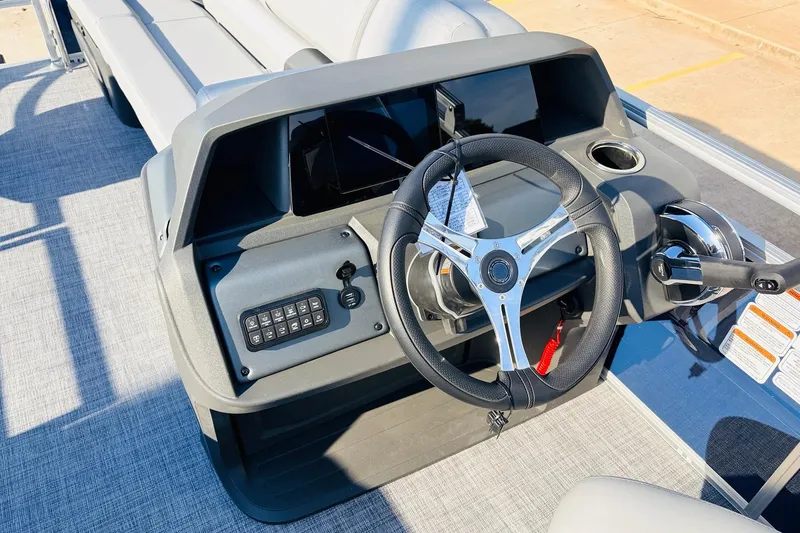 Slide: The Image of 2026 Sun Tracker SportFish 20 DLX boat dashboard with steering wheel and controls. - 32