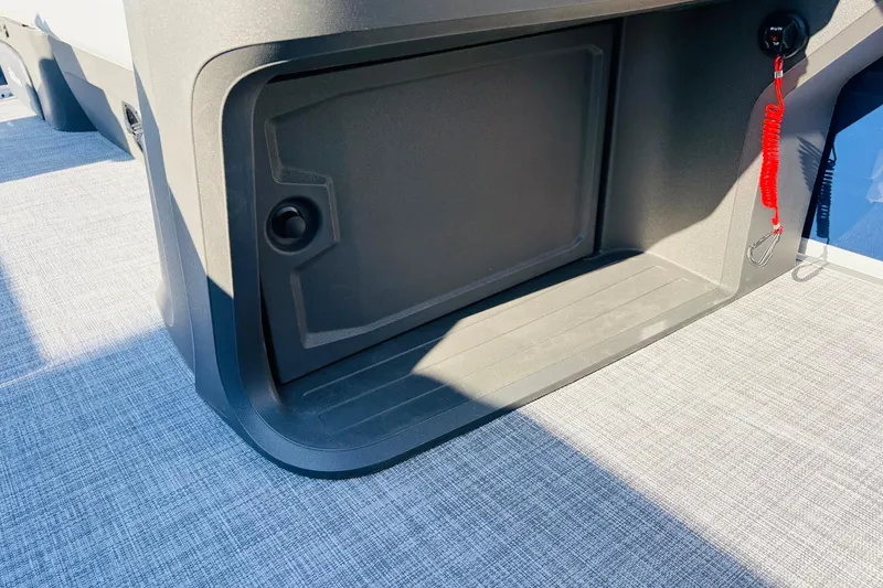 Slide: The Image of Storage compartment on 2026 Sun Tracker SportFish 20 DLX boat, featuring a safety lanyard. - 35