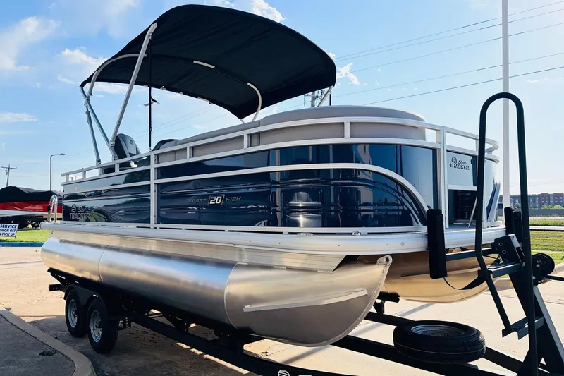 Slide: The Image of 2026 Sun Tracker SportFish 20 DLX pontoon boat on trailer, under sunny sky. - 4
