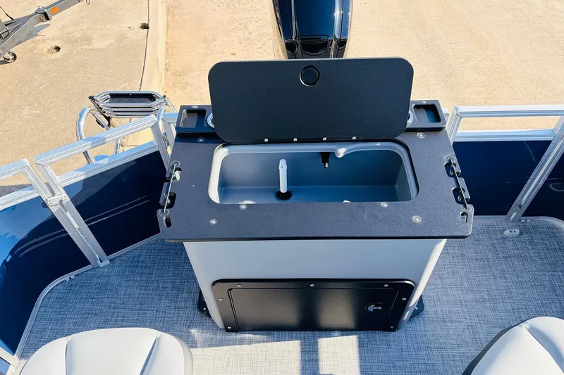 Slide: The Image of 2026 Sun Tracker SportFish 20 DLX boat with open storage compartment and seating area. - 45