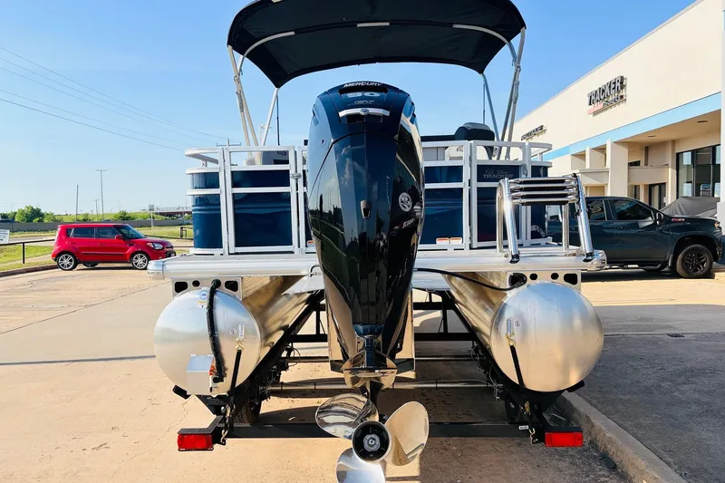 Slide: The Image of 2026 Sun Tracker SportFish 20 DLX pontoon boat with outboard motor, parked outdoors. - 7